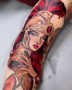 a woman's arm with a tattoo on it and a red headdress