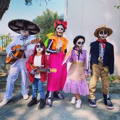 group of children dressed up in costumes for day of the dead celebration with guitar and violin