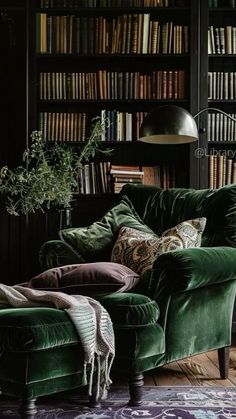 a green couch sitting in front of a book shelf filled with books