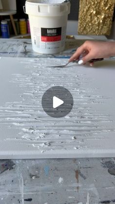 a person is using a knife to paint a piece of art