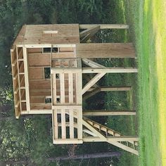 an aerial view of a wooden structure in the grass