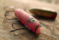 two small fishing lures sitting on top of a wooden table next to each other