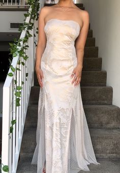 a woman in a white dress standing on some stairs