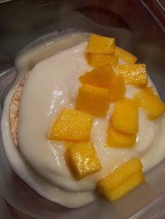 there is a dessert in a plastic container with fruit on the top and yogurt