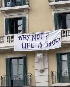 a banner that says why not? life is short on the side of a building