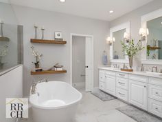 a large white bath tub sitting next to two sinks in a bathroom with mirrors on the wall