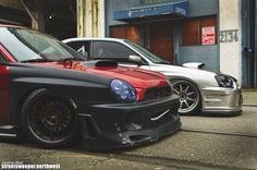 two cars parked next to each other in front of a building