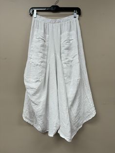 Elevate your style with our Capri Made in Italy pants. These linen pants, with an elastic waist and two front pockets, are both comfortable and chic. The loose fit and fun, trendy design will make you feel confident and effortlessly fashionable. One size fits most, making it a versatile addition to your wardrobe. Made with love in Italy. Baggy White Harem Pants With Elastic Waistband, Baggy Bottoms With Elastic Waistband For Vacation, Wide Leg Harem Pants With Pockets For Beach, Spring Side Pockets Harem Pants For Loungewear, Spring Loungewear Harem Pants With Side Pockets, Baggy Wide Leg Pants With Elastic Waistband For Beach, Spring Harem Pants With Side Pockets For Loungewear, Comfortable White Baggy Bottoms, Summer Harem Pants With Pockets For Loungewear