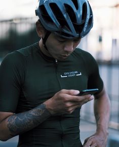 a man wearing a bike helmet looking at his cell phone