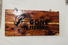 there is a sign that says gone fishing on the side of a wall with wood planks