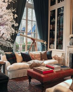 a living room filled with lots of furniture and a tree in the middle of it