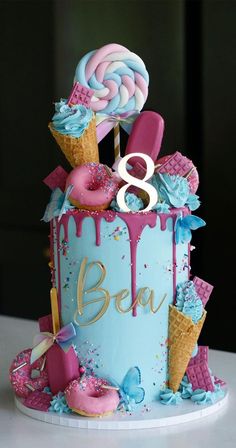 a birthday cake decorated with ice cream, lollipops and sprinkles