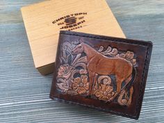 "A Men's Hand-Made, Hand-Carved, Genuine Leather, Custom Western Bi-fold Wallet This one is a tailored design for the Cowboy or Horse Lover Outfitted with a beautiful traditional Equestrian Theme Design Original sold. Now relisted Custom made to order ... Embodied with fine outstanding workmanship Only takes 7-10 days to fabricate. Perfect opportunity to personalize it at no extra cost DETAILS : - Premium Genuine Herman Oak Calf Leather--100% Made In America - Hand Saddle-stitched - can be laced Hand Tooled Brown Wallets As Gift, Rectangular Wallet With Engraved Logo As Gift, Brown Hand Tooled Trifold Wallet As Gift, Custom Brown Wallets For Gifts, Artisan Bifold Wallets Perfect As Gifts, Artisan Bifold Wallets As Gifts, Artisan Bifold Wallet As A Gift, Custom Handmade Trifold Wallet, Artisan Bifold Wallet As Gift