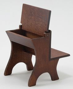 a small wooden chair with a seat on the back and foot rest in front of it