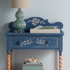 a blue table with books and a lamp on top