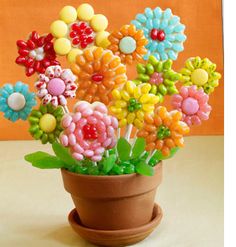 a potted plant filled with lots of colorful candies on top of a table