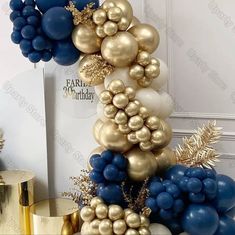 a bunch of balloons that are in the shape of a tower with gold, blue and white balloons