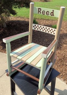 a wooden chair sitting on top of a sidewalk next to a sign that reads red