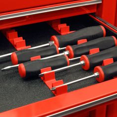 four red and black tool sets sitting on top of each other in a storage compartment