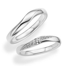 two white gold wedding rings with diamonds on each one and an engagement ring in the other