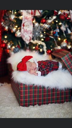 a baby is laying in a christmas present box