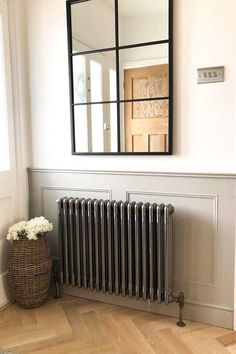 a room with a radiator and mirror on the wall