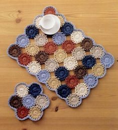 a crocheted doily with two cups on it and a cup in the middle