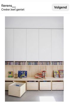 there is a room with many books on the shelves and two bins for children's toys