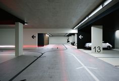 an empty parking garage with two cars parked in the space between it and another car on the other side