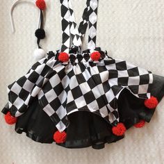 a black and white checkered dress with red pom poms on the bottom