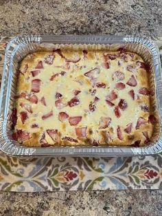 a casserole dish with ham and cheese in it sitting on a counter top