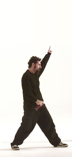 a man in black is throwing a frisbee on a white background with one hand