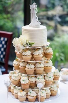 a wedding cake and cupcakes on a table