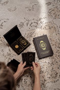 a person sitting on the floor with three cards in front of them and two books next to each other