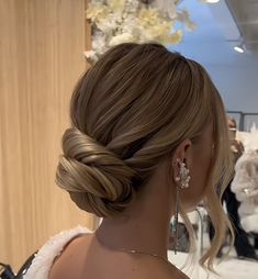 a woman with blonde hair in a low braid updo at a bridal event