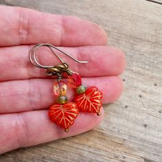 "These beaded dangle earrings are sure to add a pop of color to your wardrobe. They are just stunning! These earrings are 1.5\" in length. The smaller beads are 3 x 5mm. The leaf bead is 10 x 13mm. The ear wire shown on the earrings is a commercially made antique brass wire or titanium. If you order titanium, the ear wire is handmade. To find other items in this series, try this link. https://www.etsy.com/shop/CraftLikeAnArtist?ref=l2-shopheader-name&search_query=autumn+series16 Titanium is Pierced Czech Glass Drop Earrings, Pierced Czech Glass Dangle Earrings, Hypoallergenic Czech Glass Dangle Earrings, Hypoallergenic Czech Glass Jewelry, Adjustable Pierced Heart Drop Earrings, Czech Glass Drop Earrings, Adjustable Heart Shaped Drop Earrings, Czech Glass Earrings As A Gift, Hypoallergenic Czech Glass Earrings For Gift