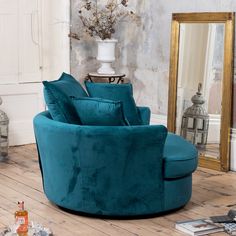 a living room with a blue chair and mirror on the floor next to a vase