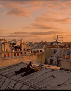 two people sitting on the roof of a building