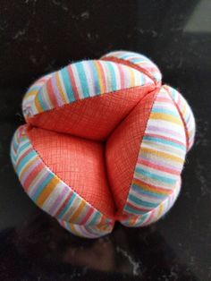 an orange striped ball sitting on top of a black table