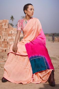 Peach georgette saree with all over pink, sea green color block pattern on pallu and aari hand work highlights. Paired with round neck silk blouse with all over traditional textiles woven stripe pattern.
Components: 2
Pattern: Hand Embroidered and Woven
Type Of Work: Stripe Pattern and Aari Work
Neckline: Round Neck
Sleeve Type: Half Sleeves
Fabric: Silk, Georgette
Color: Peach
Other Details: 
Drop tasselled pallu edges
Contrast piping details
Occasion: Sangeet - Aza Fashions Transitional Pink Raw Silk Pre-draped Saree, Fusion Style Pre-draped Saree For Festivals With Unstitched Blouse, Pink Raw Silk Pre-draped Saree With Dupatta, Pink Silk Pre-draped Saree With Cutdana, Pink Tissue Silk Pre-draped Saree With Unstitched Blouse, Pink Pre-draped Tissue Silk Saree With Unstitched Blouse, Transitional Pink Chanderi Pre-draped Saree, Pink Silk Sets With Unstitched Blouse, Pink Silk Set With Unstitched Blouse