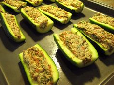 zucchini stuffed with cheese and other toppings sitting on a baking sheet in an oven