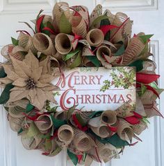 a christmas wreath with burlocks and poinsettis on the front door