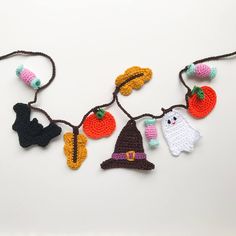 crocheted halloween decorations are hanging on a string with pumpkins and ghostes