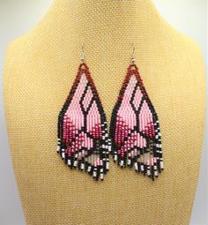 pink and black beaded earrings on top of a mannequin's torso