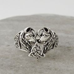 Embark on a mystical journey with our Celtic Trinity Knot Love Wolves Ring, a symbol of ancient magic and eternal love. Forged in the spirit of myth and legend, this ring weaves together the allure of the wild with the timeless beauty of Celtic lore. In the gentle embrace of this piece, two wolves, creatures of the moonlit realms and ancient forests, come together. Their profiles meet, creating a heart, a sacred space where love dwells and endures, whispering tales of loyalty and passion that transcend time. At the center of this loving embrace lies the Trinity Knot, an eternal Celtic symbol. Its unbroken lines dance and intertwine, telling stories of life's interconnections, the endless journey of the soul, and the deep bonds that unite us all. This ring is more than a piece of jewelry; i Rune Ring, Ancient Magic, Instagram Ring, Loving Embrace, Celtic Symbol, Wolf Ring, Celtic Trinity Knot, Trinity Knot, Jewelry Men