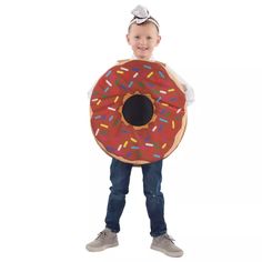 a young boy is holding a giant donut costume