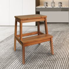 a wooden step stool sitting on top of a rug