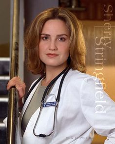 a woman with a stethoscope standing next to a stair case and looking at the camera