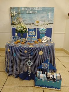 a table topped with lots of cakes and desserts next to a sign that says battesmo tobia