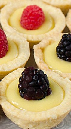 small desserts with fruit on them sitting on a plate